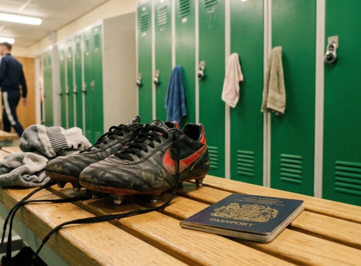 A passport resting on a locker room bench next to unlaced football boots.
