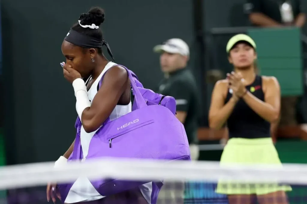 A low-angle shot of a medical bag resting on the gritty purple surface of a hard court under harsh sunlight.