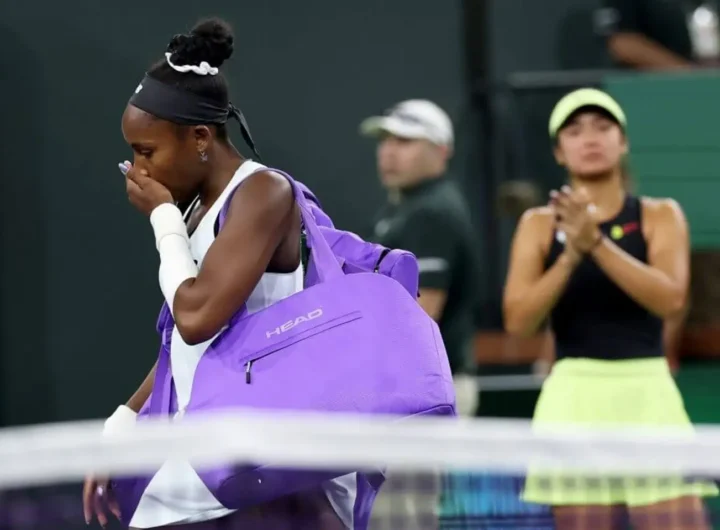 A low-angle shot of a medical bag resting on the gritty purple surface of a hard court under harsh sunlight.